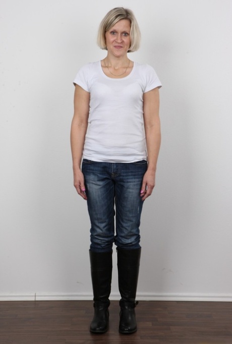 Mature woman crosses her legs after removing all of her clothing