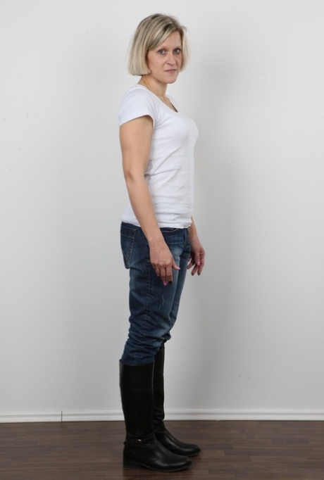 Mature woman crosses her legs after removing all of her clothing