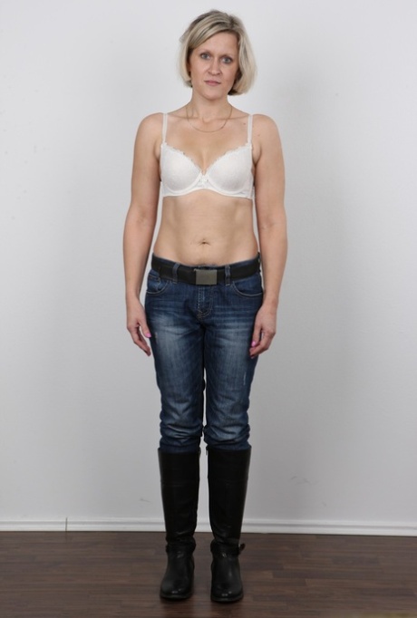 Mature woman crosses her legs after removing all of her clothing