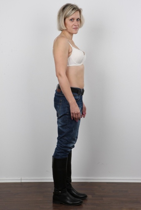 Mature woman crosses her legs after removing all of her clothing