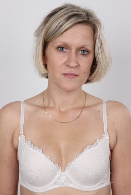 Mature woman crosses her legs after removing all of her clothing