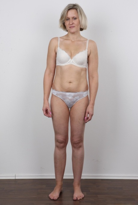 Mature woman crosses her legs after removing all of her clothing