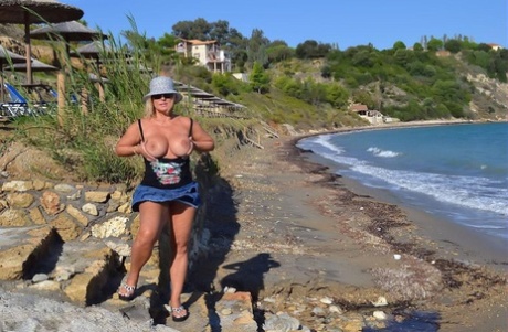 Hugely busty mature slut Chrissy swims and lounges at the beach stark naked