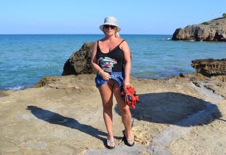 Hugely busty mature slut Chrissy swims and lounges at the beach stark naked