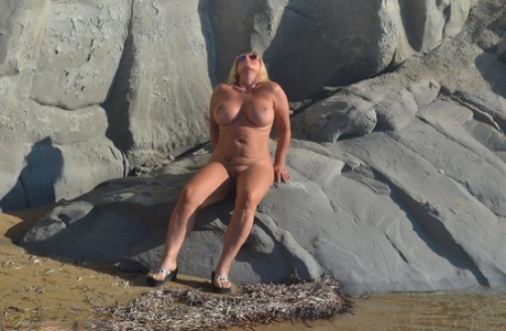 Hugely busty mature slut Chrissy swims and lounges at the beach stark naked