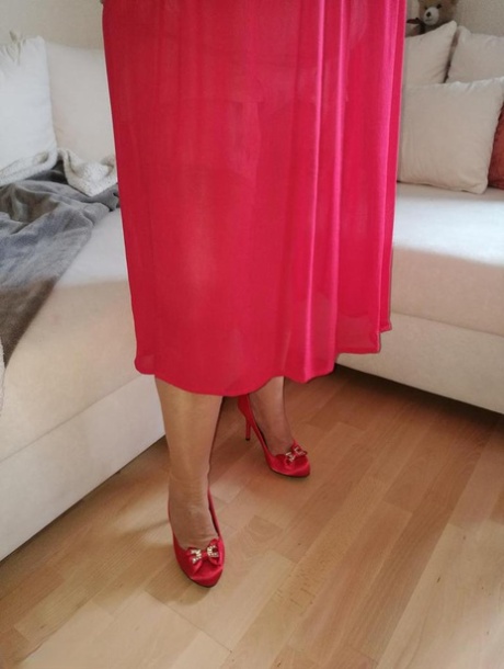 Horny oma Caro hikes up long red dress to spread her hairy vagina