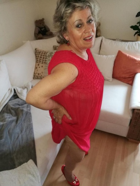Horny oma Caro hikes up long red dress to spread her hairy vagina