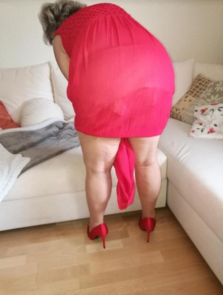 Horny oma Caro hikes up long red dress to spread her hairy vagina