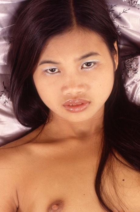 Petite Thai girl stretches out her wet pussy after dildoing on bed