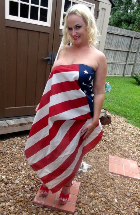 Blonde amateur Dee Siren holds an American flag while topless in a red thong