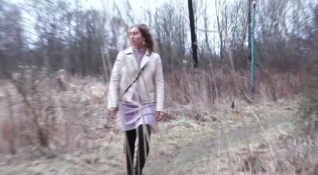 Short taken girl Rita squats for a piss behind a building in the countryside