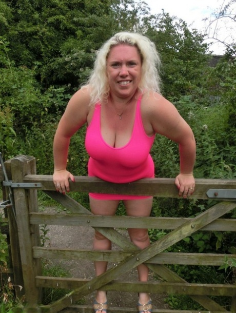 Mature blonde Barby shows her big tits and bald twat while changing clothing