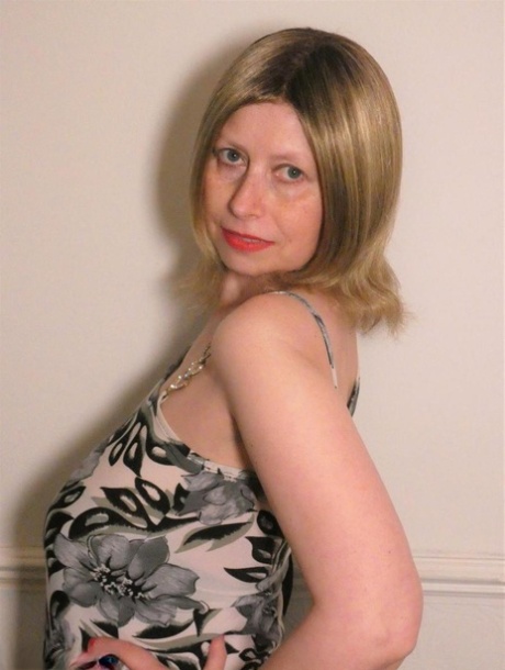 Older amateur Posh Sophia models pink lingerie before changing into a dress