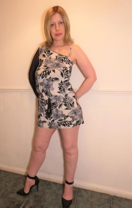 Older amateur Posh Sophia models pink lingerie before changing into a dress