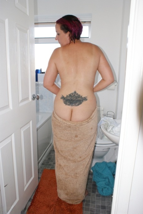 Older tattooed redhead Sara Banks gets totally naked while taking a shower