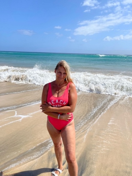 Middle-aged blonde Sweet Susi gets totally naked on a sandy beach