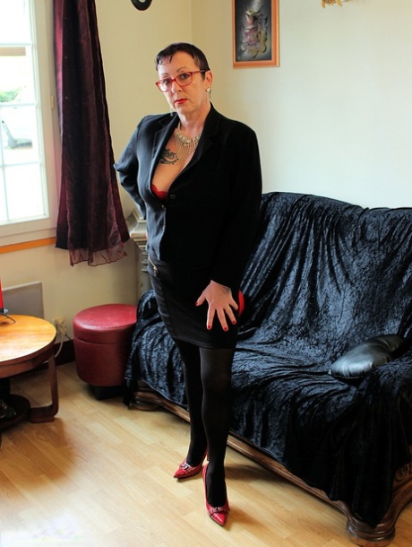 Mature woman Mary Bitch displays her pierced bush in sexy stockings