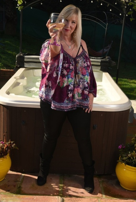 Fat older blonde Melody peels off black leggings afore an outdoor hot tub