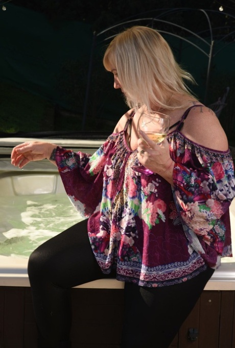 Fat older blonde Melody peels off black leggings afore an outdoor hot tub