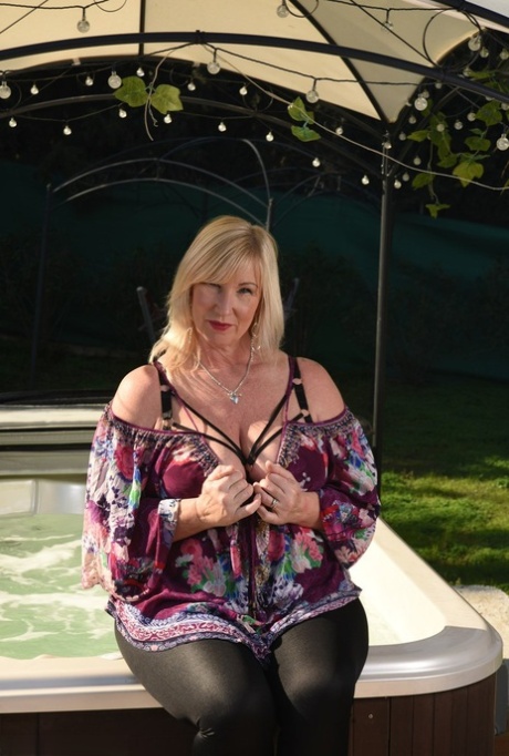 Fat older blonde Melody peels off black leggings afore an outdoor hot tub