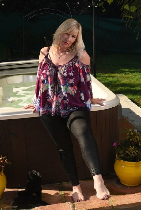 Fat older blonde Melody peels off black leggings afore an outdoor hot tub