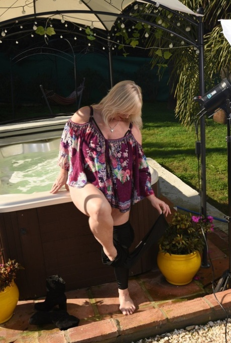 Fat older blonde Melody peels off black leggings afore an outdoor hot tub