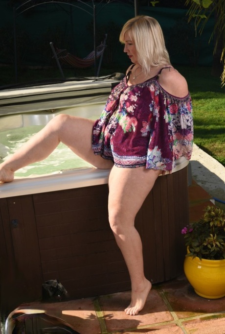 Fat older blonde Melody peels off black leggings afore an outdoor hot tub