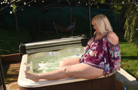 Fat older blonde Melody peels off black leggings afore an outdoor hot tub