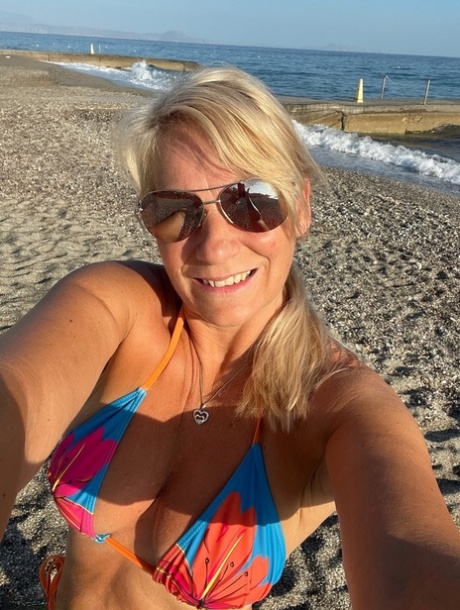 Middle-aged blonde Sweet Susi releases her natural tits and twat from a bikini