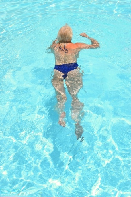 Mature blonde Dimonty looses her natural tits from swimwear at the pool