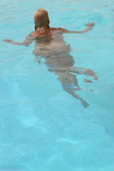 Mature blonde Dimonty looses her natural tits from swimwear at the pool