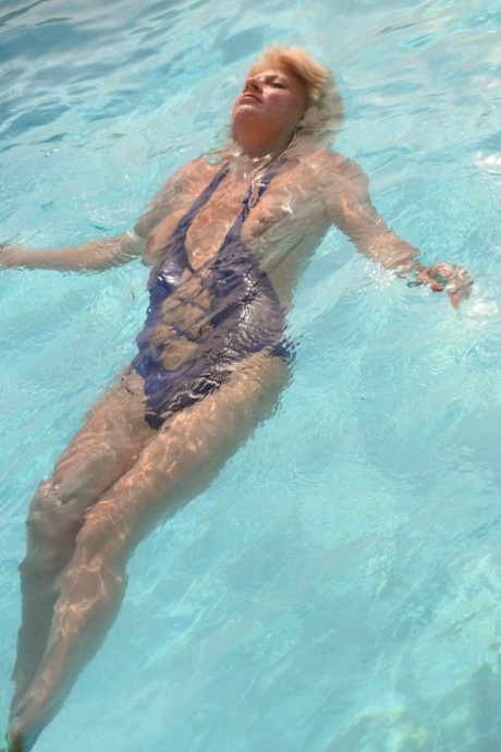 Mature blonde Dimonty looses her natural tits from swimwear at the pool