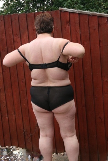 Overweight British woman Kinky Carol gets naked in high heels in a backyard