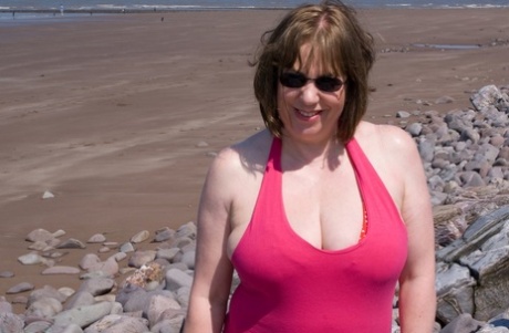 Mature UK plumper Speedy Bee takes off her bikini top during a trip to the sea