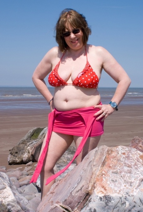 Mature UK plumper Speedy Bee takes off her bikini top during a trip to the sea