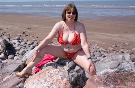 Mature UK plumper Speedy Bee takes off her bikini top during a trip to the sea