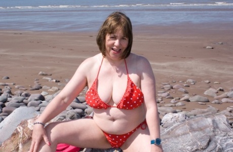 Mature UK plumper Speedy Bee takes off her bikini top during a trip to the sea