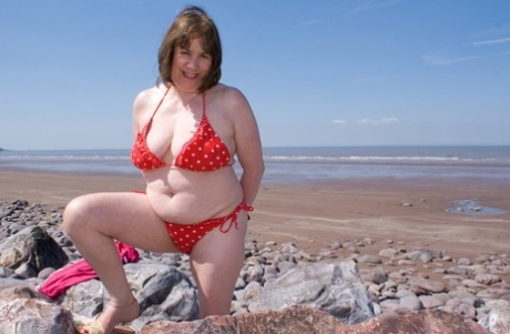 Mature UK plumper Speedy Bee takes off her bikini top during a trip to the sea