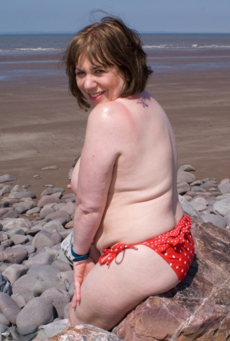 Mature UK plumper Speedy Bee takes off her bikini top during a trip to the sea