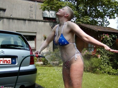 Mature woman Tiffany Pearl soaks herself with a hose while taking off a bikini