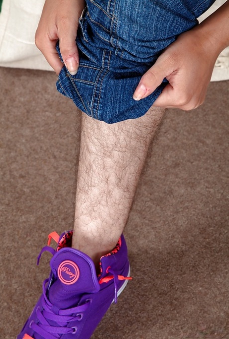 Tattooed hirsute woman shedding jeans to show off hairy legs and beaver