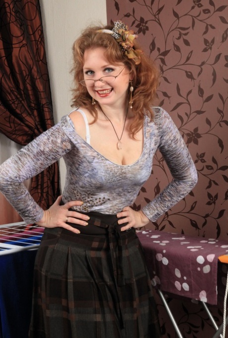 Naughty mature woman in glasses rolls of her hose to finish act of undressing