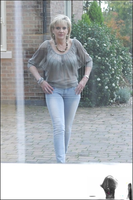 Nasty mature vixen revealing her jugs and lowering her blue jeans