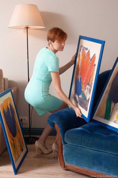 Hairy lady Ginta shows a collection of her paintings and spreads her pussy