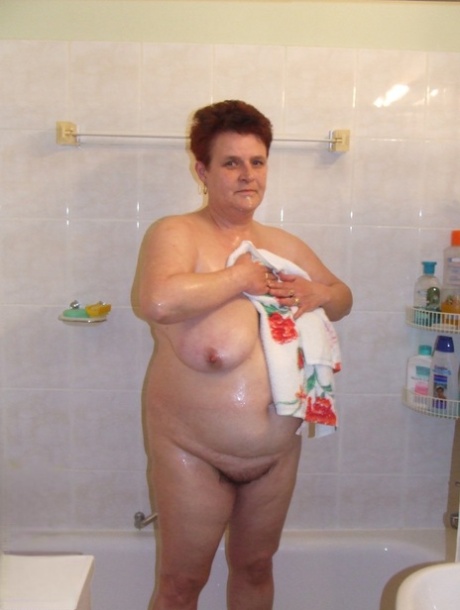 Chubby housewife Ingeborg plays with her saggy breasts in the bathroom