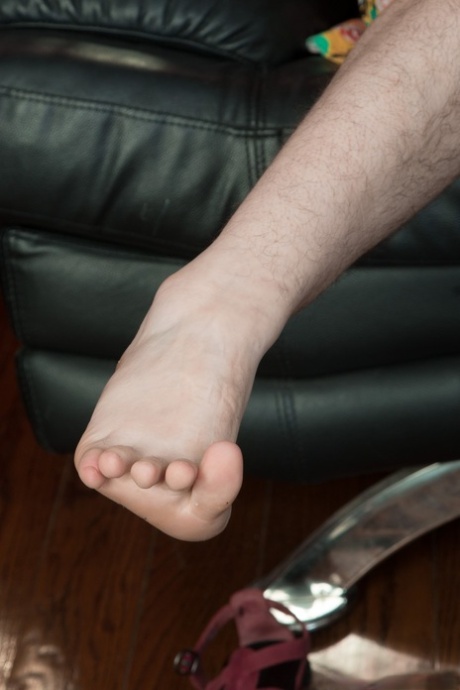 Girl with big tits and glasses Tamar reveals her hairy legs and twat on a sofa