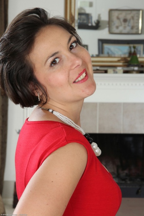 Mature Carlita Johnson removes her red dress and spreads her ass on the floor