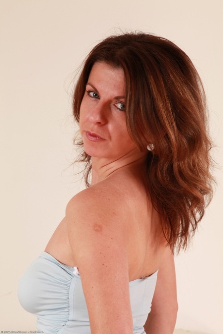 Brunette mature Patris removes her dress and displays her trimmed cunt