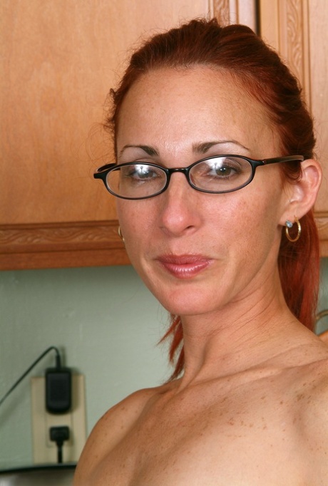 Redheaded amateur housewife Skyla undresses and poses in the kitchen