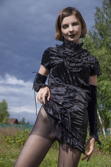Gothic beauty Lady Phanthom stripping & spreading her furry pussy outdoors